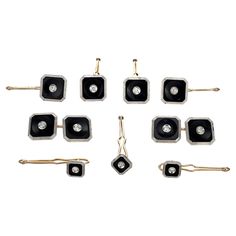 six pairs of black and white square earrings with diamonds on each earring, set against a white background