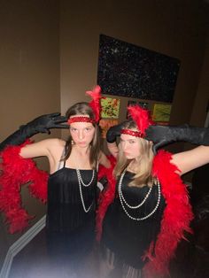 two young women dressed in flappers and garb, posing for the camera with their hands on their hips