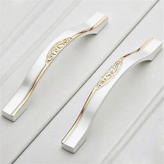 two white and gold toothbrushes sitting on top of each other