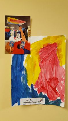 two children's paintings are hanging on the wall next to each other, and one is made with colored paper