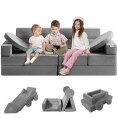 three children sitting on a gray couch with matching footrests