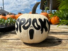 a pumpkin with the word rock painted on it sitting in front of other pumpkins