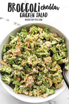 a bowl filled with broccoli and chicken salad on top of a marble counter