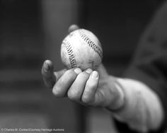 a person holding a baseball in their hand