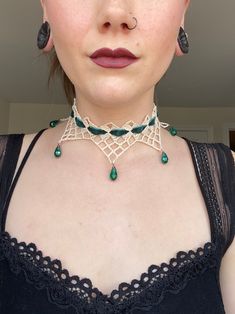 a close up of a woman wearing a choker and necklace with beads on it