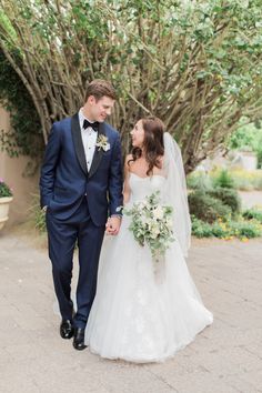 a bride and groom holding hands walking together