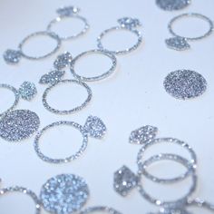 silver glitter circles are arranged on a white surface