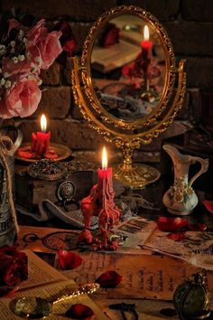 a table topped with lots of different types of items and candles in front of a mirror