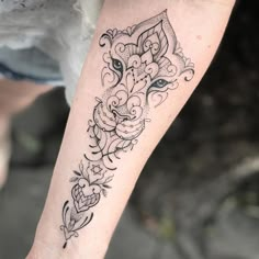 a woman's arm with a tattoo on it and an animal head in the middle