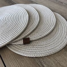 three white round rugs sitting on top of a wooden floor next to each other