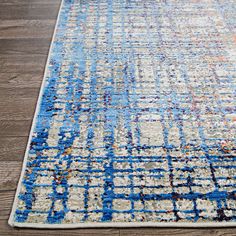 a blue and white area rug with an abstract design on the bottom, along with wood flooring