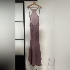 a dress hanging on a hanger in front of a mirror