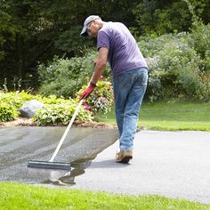 a man is cleaning the driveway with a mop