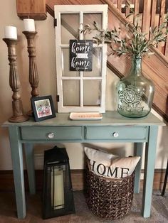 a blue table with some pictures on top of it and two vases filled with flowers