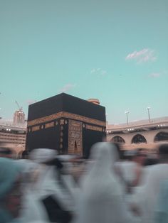 many people are walking around in front of the ka'bah, one of which is black and gold