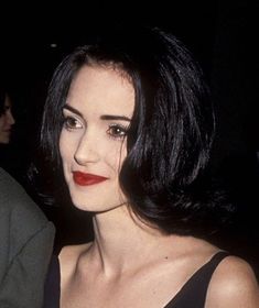 a close up of a person wearing a black dress and red lipstick at an event