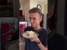 a man holding a plate with cake on it and another person looking at the camera