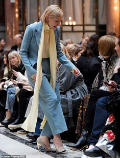 a woman is walking down the runway at a fashion show