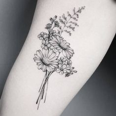 a black and white flower tattoo on the right thigh, with daisies in it