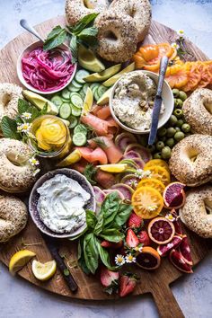 a platter with bagels, vegetables and dips