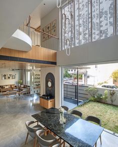 a dining room table with chairs and a clock on the wall