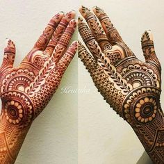 two hands with henna designs on them