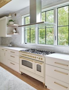 a kitchen with an oven, stove and counter tops in front of a large window