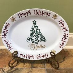 a white platter with a happy holidays tree on the front and words that spell merry