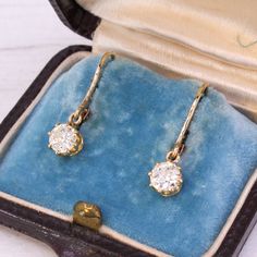 A vibrant pair of antique diamond earrings. The old European cut diamonds are white, bright and glowing, and are set in 18k yellow gold eight claw coronet collets which hang from hinged lever-backs. Accompanied by an independent jewellery report from IGR (#30310591). Cut - Old European cuts. Colour - H and I. Clarity - VS2 and SI1 Carat - A total approximate weight of 1.01 carat. Circa - 1910. Measurements - From top the bottom the diamond is 23.5mm. The diamonds are 5.1mm in diameter. Weight - Vintage Yellow Gold Diamond Earrings For Pierced Ears, Classic Formal Rose Cut Diamond Earrings, Formal Classic Rose Cut Diamond Earrings, Formal Vintage Diamond Earrings, Wedding Diamond Earrings With Lever Back, Formal Drop Diamond Earrings With Single Diamond, Formal Single Diamond Drop Earrings, Classic Single Diamond Drop Earrings, Classic Drop Diamond Earrings With Single Diamond