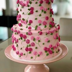 a three layer cake decorated with pink roses