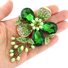 Stunning large flower brooch featuring shiny emerald teardrop stones and sparkling clear and green rhinestones, can be used for your DIY project - party outfit accessory, ceremony lapel decoration, dress embellishment, crafts, scrap booking, jewelry gift and much more.  Size: 4 inch high 2 1/2 inches wide Stones color: green and clear Pearls: light green Metal: Gold plated This big rhinestone brooch can be ordered with pin in the back to add to gown or sash, to add to decorative pillow, or any number of other craft projects or without the pin as a flat back embellishment for your sew-on, glue-on DIY project. More GREEN brooches - https://www.etsy.com/shop/Crystalitzy?section_id=20249486 Please check for more items in my Shop - https://www.etsy.com/shop/Crystalitzy Green Brooch, Dress Sash, Green Metal, Bridal Sash, Dress Pin, Crystal Brooch, Green Crystal, Green Flower, Rhinestone Jewelry