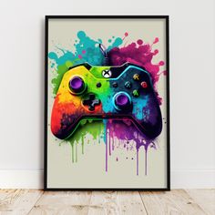 a colorful video game controller with splattered paint on the wall in front of it