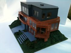 a paper model of a house sitting on top of a green field