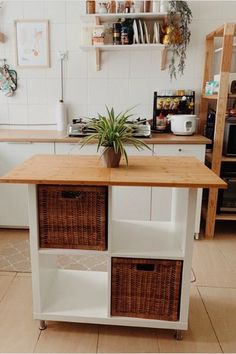 a kitchen island with wicker baskets on it and a potted plant in the center