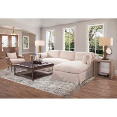 a living room filled with furniture and windows next to a rug on top of a hard wood floor