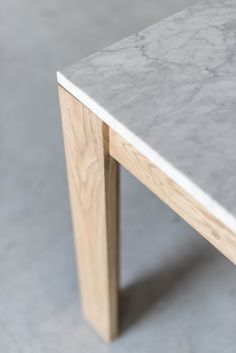 a white marble table with wooden legs