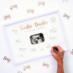 a person holding a pen in front of a framed photo with the words twinkle twinkle on it