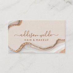 a business card with gold foil and marble texture on the front, featuring an elegant swirl design