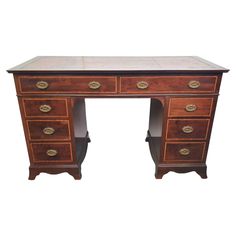 an antique wooden desk with marble top and brass hardware on the bottom, against a white background