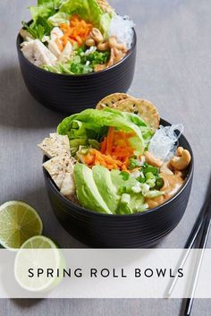 two black bowls filled with salad and tortilla chips next to lime wedges