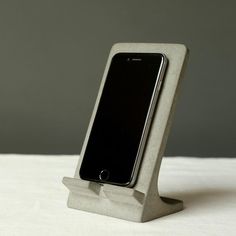 an iphone is sitting in a concrete holder