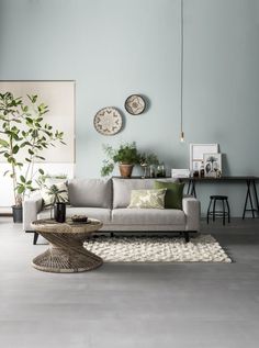 a living room with two clocks on the wall and a couch in front of it