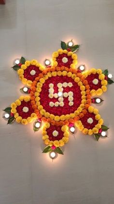 a decorated rangolite with candles and flowers on the floor