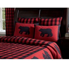 a bed with red and black plaid comforter, pillows and pillow cases on it