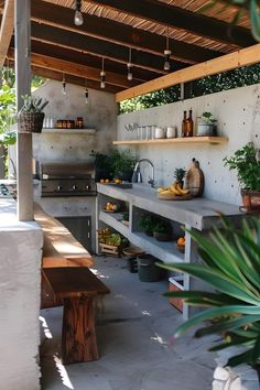 an outdoor kitchen with potted plants on the counter and shelves above it that are built into the wall