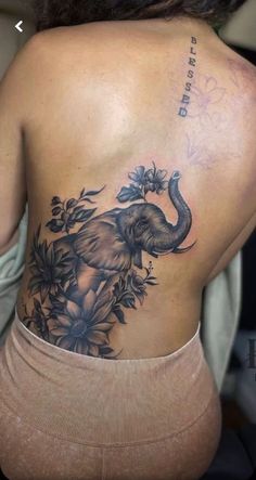 an elephant tattoo on the back of a woman