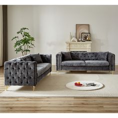 a living room with two gray couches and a coffee table in front of it