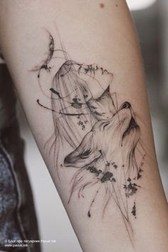 a woman's arm with a tattoo on it and an image of a wolf