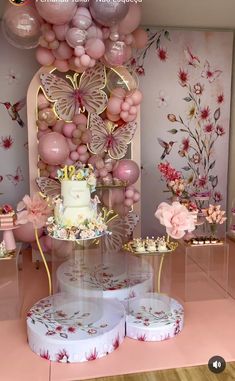 a table topped with a cake and lots of balloons