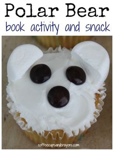 a polar bear cupcake with white frosting and black chocolates on it's face